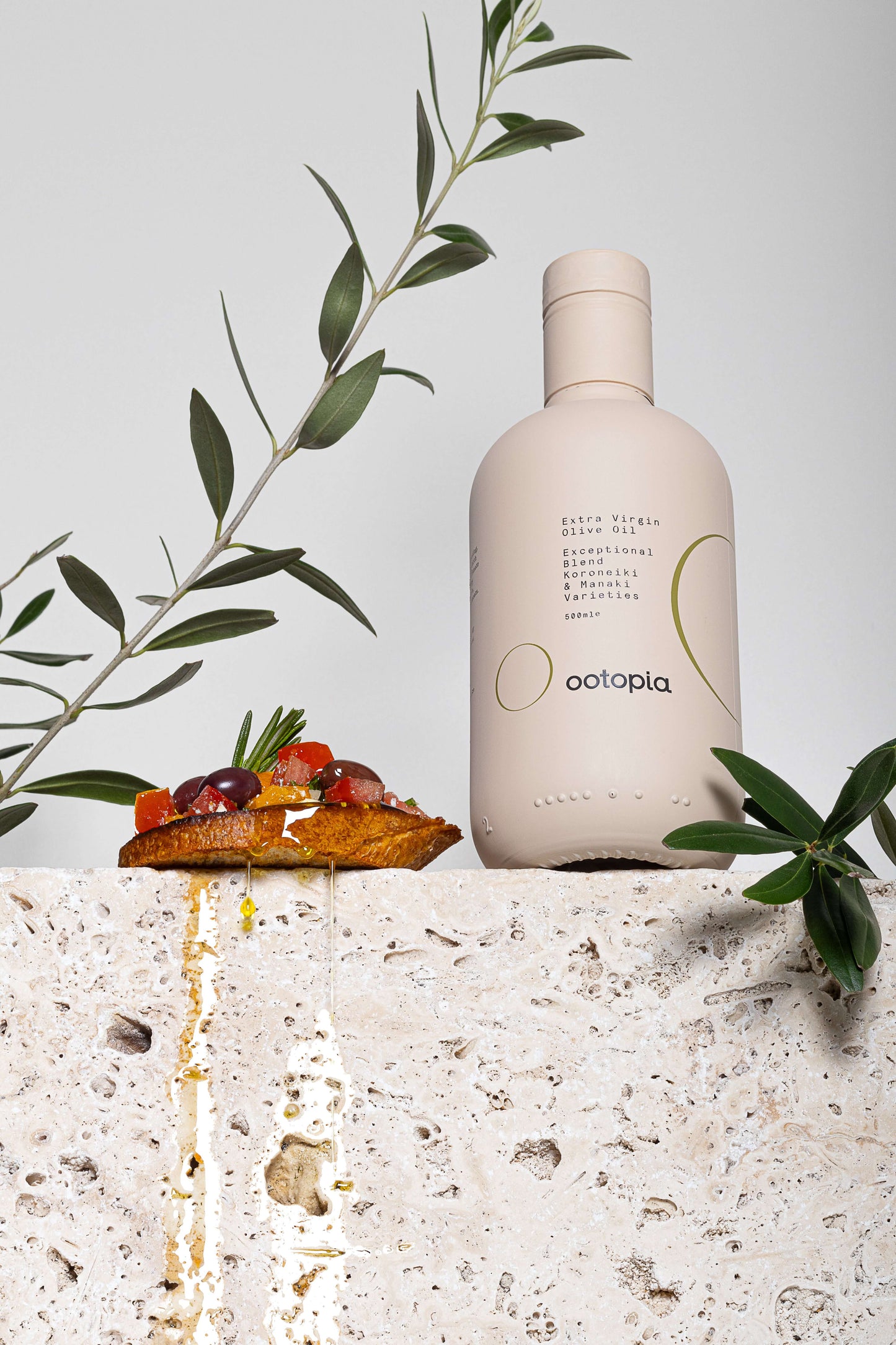 Ootopia Greek Extra Virgin Olive Oil bottle with olives and toast, showcasing rich flavors and premium quality.