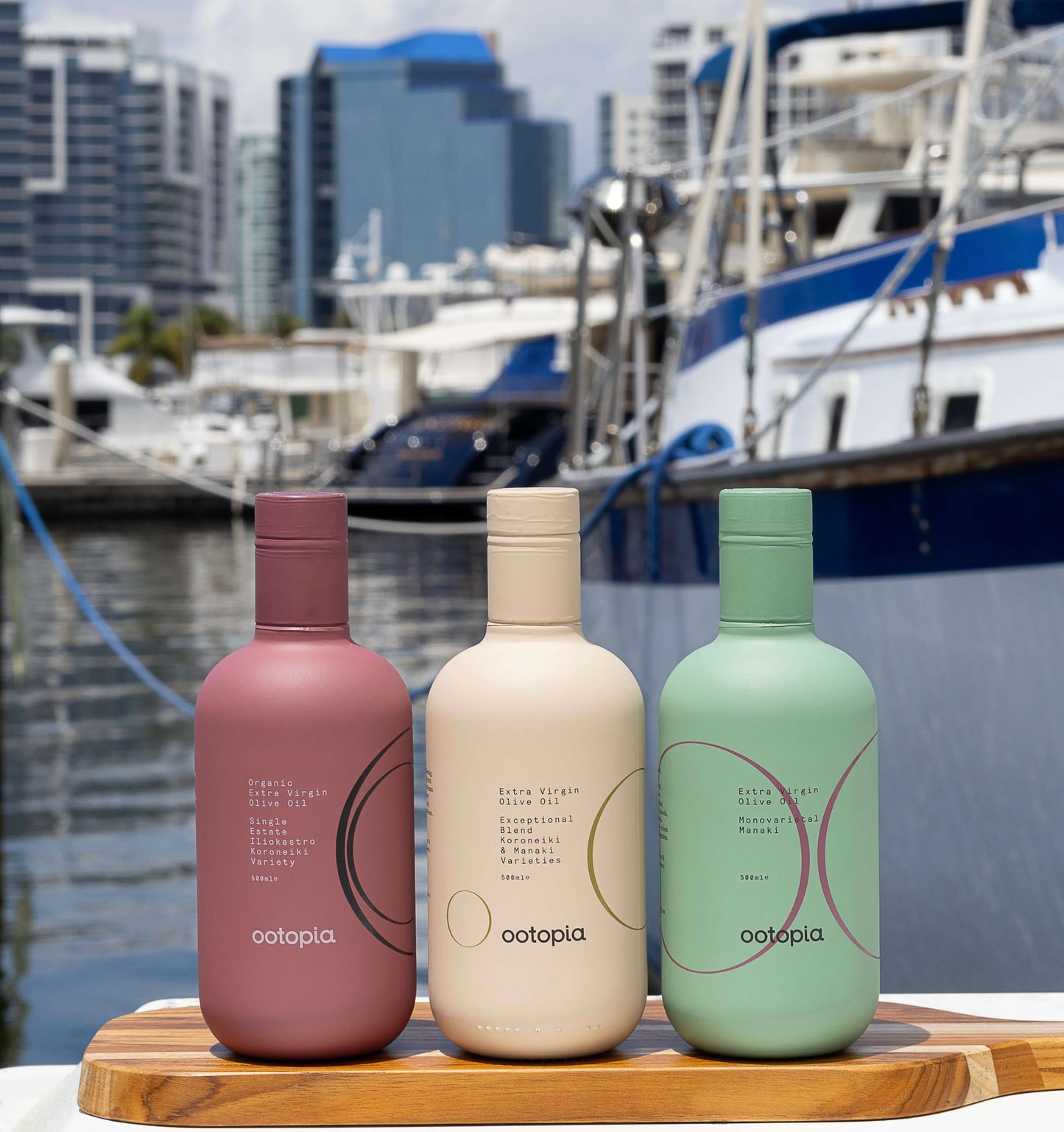 Ootopia extra virgin olive oil bundles displayed by the marina, showcasing three unique bottle designs.